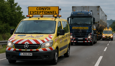 Eskortfordon som följer en konvoj med överdimensionerad transport på en europeisk motorväg